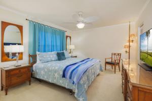 1 dormitorio con 1 cama, vestidor y TV en Intercoastal Dreams 102, en Port Orange