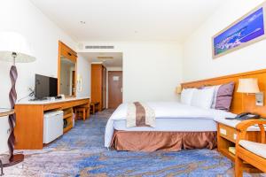 Habitación de hotel con cama y TV en Yaling Hotel, en Magong