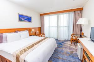 une chambre d'hôtel avec un lit et une télévision dans l'établissement Yaling Hotel, à Magong