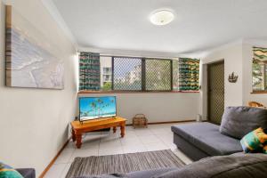 a living room with a couch and a tv at Sha na na Unit 3 Kings Beach Gem in Caloundra