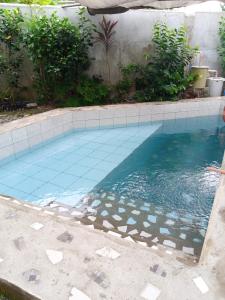 a swimming pool with blue tiles on the floor at Lucky777 Homestay in Mambajao