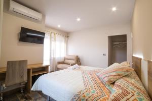 a bedroom with a bed and a desk and a chair at Villa Oasis de Bardenas & Piscina in Valtierra +35 photos