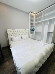 a large white bed in a room with white walls at Sunrise City 1 Bed Room in Ho Chi Minh City
