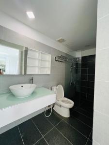 a bathroom with a sink and a toilet and a mirror at Sunrise City 1 Bed Room in Ho Chi Minh City