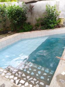 a swimming pool with a tile floor and blue water at Lucky777 Homestay in Mambajao