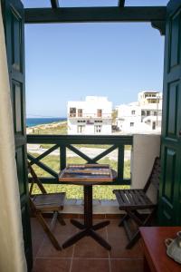 una mesa y sillas en un balcón con vistas al océano en Apollon Hotel, en Naxos Chora