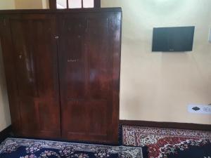 un grande armadio in legno con TV a parete di Hotel Wazir Palace a Srinagar