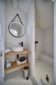 ein Badezimmer mit einem Waschbecken und einem Spiegel auf einem Regal in der Unterkunft IMMOGROOM - Cosy - Renovated duplex - Close to the beach in Cannes