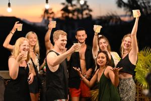 a group of people cheering with their hands in the air at Lushy Hostel Canggu in Canggu