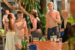 a group of young men and women standing around a table at Lushy Hostel Canggu in Canggu