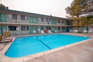 a large swimming pool in front of a hotel at Motel 6-Winnemucca, NV in Winnemucca