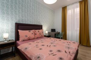 a bedroom with a bed with a pink comforter at Hostel Antique in Pula