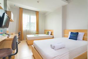 Habitación de hotel con 2 camas y TV en Urbanview Hotel Syariah Dapen Pontianak by RedDoorz, en Siantan