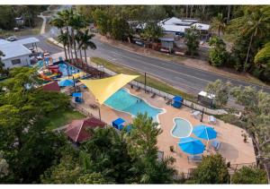 an aerial view of a swimming pool with umbrellas at Discovery Parks - Airlie Beach in Airlie Beach