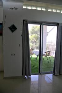 Habitación con puerta corredera de cristal y vistas a un patio. en במיוחד בשבילך צימר ערד, en Arad