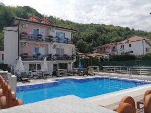a hotel with a swimming pool in front of a building at Villa Mimi in Peštani