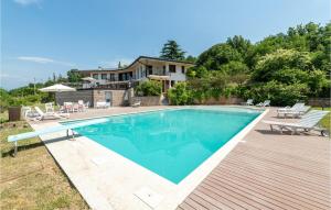 a swimming pool with chairs and a house at Nice Home In Albisano With Sauna in Albisano