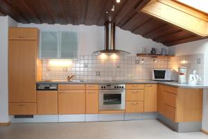 a kitchen with wooden cabinets and a stove top oven at Haus Ganahl in Vandans