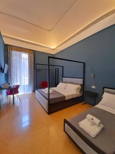 - une chambre avec 2 lits, un bureau et un lit sidx sidx sidx dans l'établissement Mamamia al Teatro Biondo, à Palerme