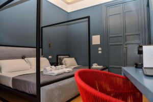 1 dormitorio con 1 cama y 1 silla roja en Mamamia al Teatro Biondo en Palermo