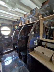 a bathroom with a van with a sink and a mirror at Alexandros by the Beach - Serifos in Livadakia