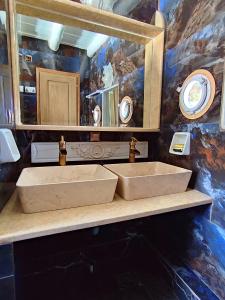 a bathroom with two sinks in front of a mirror at Alexandros by the Beach - Serifos in Livadakia