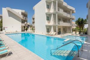 a swimming pool in front of a building at Summer Beach Hotel in Georgioupoli