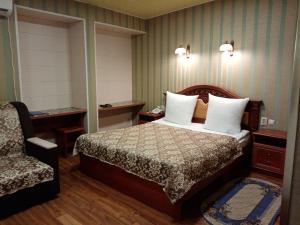 ウラン・ウデにあるKhutorok Hotelのベッドと椅子付きのホテルルーム