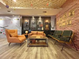 a living room with a couch and two chairs at Roaders Hotel Hualien Dongda in Hualien City