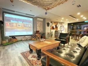 a living room with a large projection screen at Roaders Hotel Hualien Dongda in Hualien City