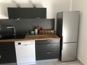 kuchnia z lodówką i białą zmywarką do naczyń w obiekcie Appartement a proximité du centre et de la Plage a Meze w mieście Mèze +6 zdjęć