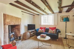 a living room with a couch and a fireplace at Lakeside Cottage in Nantwich