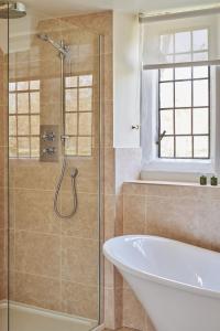 a bathroom with a tub and a glass shower at Lakeside Cottage in Nantwich +19 photos