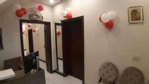 a room with three mirrors and red and white balloons at Hotel Royal Defence in Lahore
