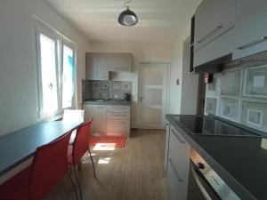 a kitchen with a black counter and red chairs at VETULONIA ROMANTICA in Vetulonia +33 photos