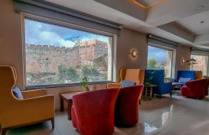 une salle d'attente avec des chaises et une grande fenêtre dans l'établissement Golden Walls Hotel, à Jérusalem