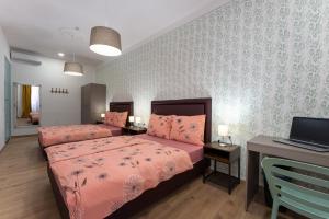 a bedroom with two beds and a laptop on a desk at Hostel Antique in Pula