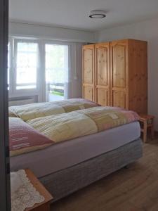 a bedroom with a bed and wooden cabinets at Bergblick 35 in Bolgen