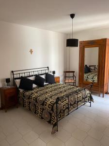 ein Schlafzimmer mit einem Bett und einem Spiegel in der Unterkunft Villa Sara - Villa con piscina in Marina di Ragusa + 55 Fotos