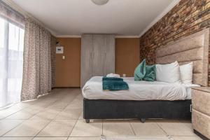 um quarto com uma cama grande e uma parede de tijolos em Bluewater Bay Vakhusi on 7 Joycelyn em Port Elizabeth