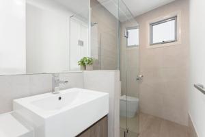 a white bathroom with a sink and a toilet at Bay and Relax in Apollo Bay