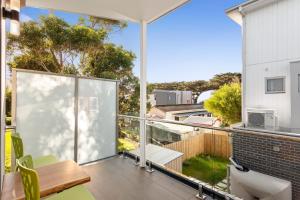 a balcony with a table and chairs and a view of the yard at Bay and Relax in Apollo Bay