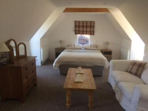 a bedroom with a bed and a couch and a table at The Annexe in Sturminster Newton