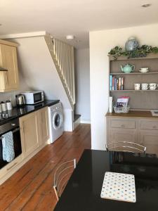 a kitchen with a dining table and a kitchen with a staircase at The Annexe in Sturminster Newton