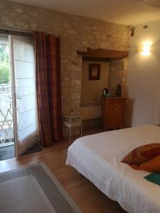 een slaapkamer met een bed en een glazen schuifdeur bij Castel Mazars in Castelnau-de-Montmiral