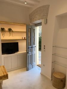 a living room with a tv and a door at Corfudodici in Corfu Town