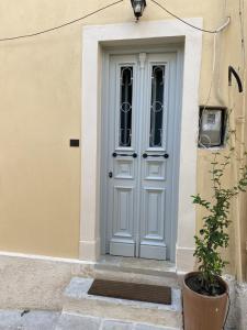 a white door of a building with a potted plant at Corfudodici in Corfu Town