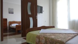 a bedroom with two beds and a tv on the wall at Hotel Ritsa in Ureki