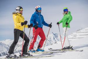 3 Personen auf Skiern auf einer schneebedeckten Piste in der Unterkunft Ferienwohnung Alex in Heiligenblut