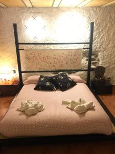 a bed with two pillows on top of it at Casa el Pelaire in Perarrua